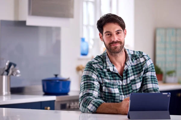 Tatil Mağazadan Çalışmak Için Mutfakta Dijital Tablet Kullanan Bir Adamın — Stok fotoğraf