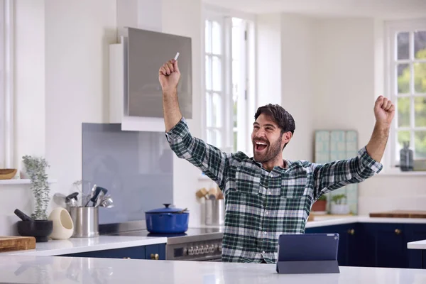 Άνθρωπος Ψηφιακή Ταμπλέτα Στην Κουζίνα Γιορτάζοντας Καλά Νέα — Φωτογραφία Αρχείου