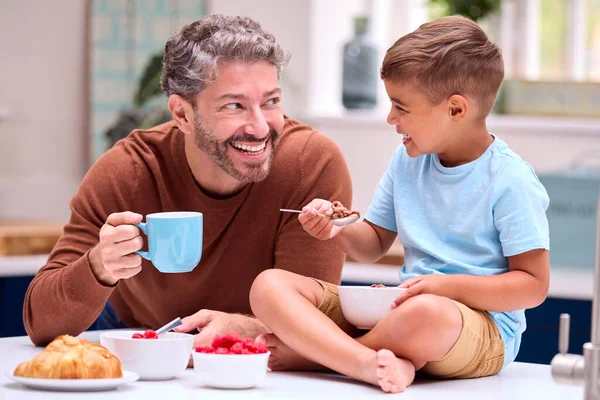 Familia Con Padre Cocina Con Hijo Sentado Mostrador Comiendo Desayuno —  Fotos de Stock