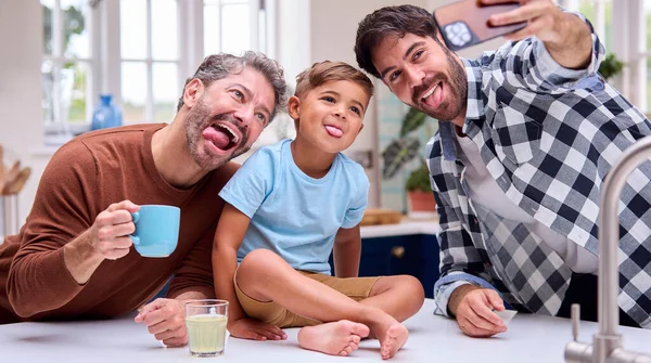 Aynı Cinsiyetten Iki Baba Mutfakta Oğlu Tezgahta Otururken Selfie Çektirmek — Stok fotoğraf