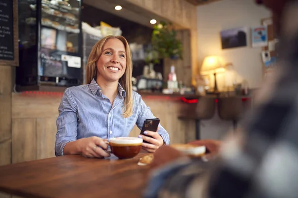 Paar Sitzt Coffeeshop Tisch Und Schaut Gemeinsam Aufs Handy — Stockfoto