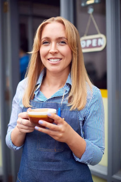 女性オーナーやスタッフのポートレートコーヒーショップの外に立ち熱い飲み物を保持 — ストック写真