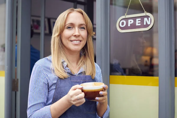 女性オーナーやスタッフのポートレートコーヒーショップの外に立ち熱い飲み物を保持 — ストック写真