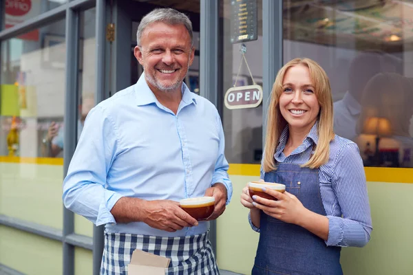 男性と女性のオーナーやスタッフのポートレートコーヒーショップの外に立ってホットドリンクを保持 — ストック写真