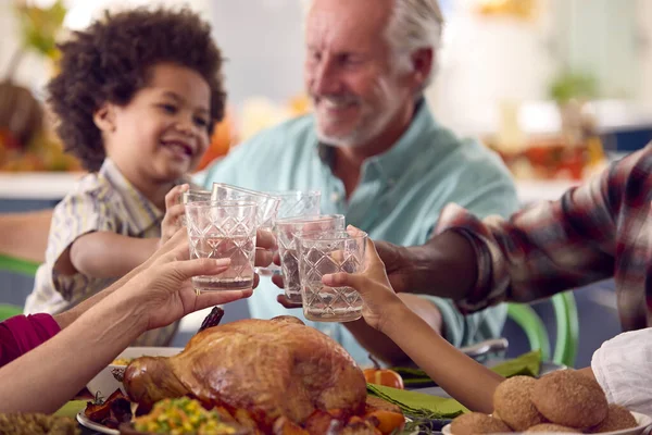 家庭での感謝祭を祝う多世代家族食事と水で乾杯 — ストック写真