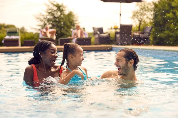 在户外游泳池里玩乐泼洒的暑假 向混血族微笑 — 图库照片