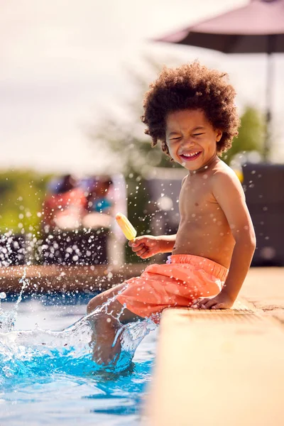 Rodina Letní Dovolenou Chlapcem Jíst Led Lízátko Cákání Okraji Bazénu — Stock fotografie