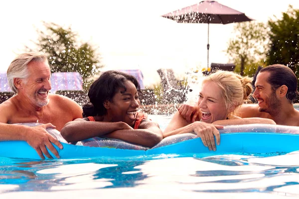 成熟した両親と大人の休暇を持つ笑顔の家族夏休みにプールで空中 — ストック写真