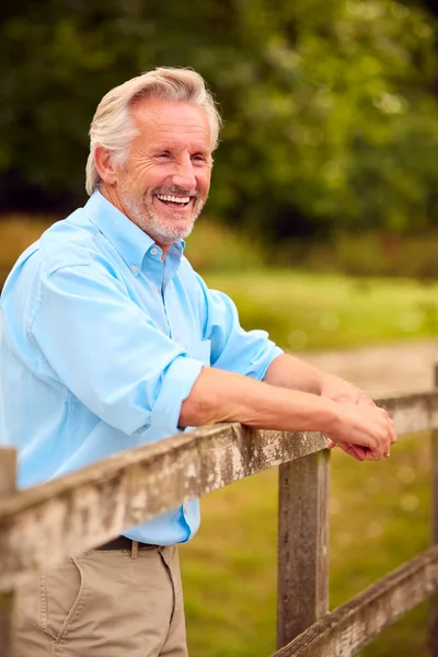 Portrait Smiling Casually Dressed Mature Senior Man Leaning Fence Walk — Stock Photo, Image