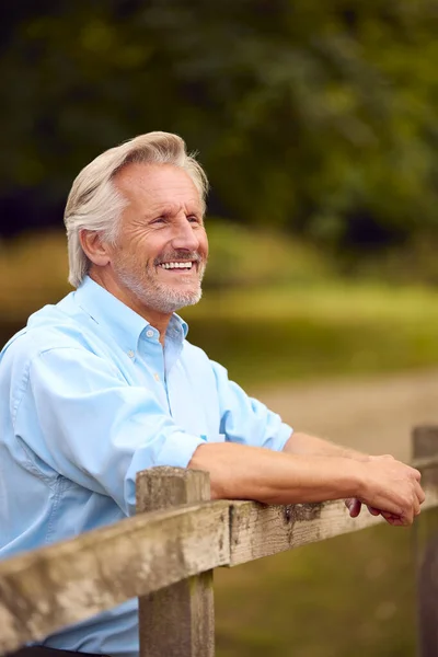 Lächelnd Lässig Gekleidet Reif Oder Senior Mann Lehnt Auf Zaun — Stockfoto