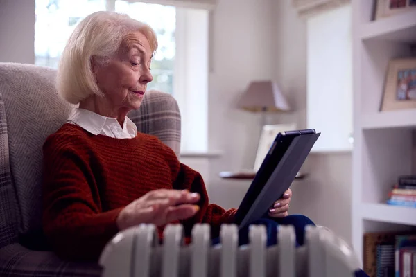 Senior Vrouw Met Digitale Tablet Warm Houden Door Draagbare Radiator — Stockfoto