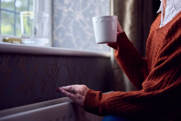 Senior Vrouw Met Warme Drank Proberen Warm Houden Door Radiator — Stockfoto