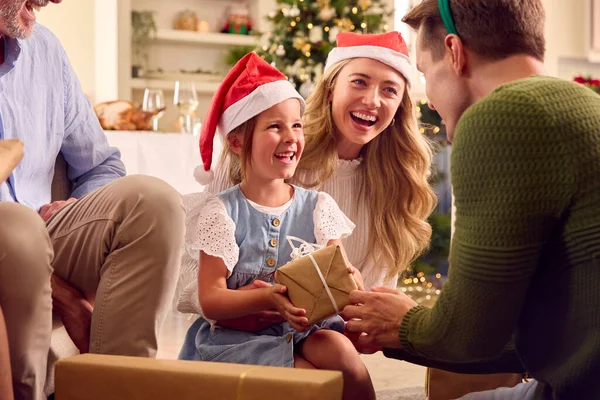サンタの帽子と釣り人をかぶって自宅でクリスマスを祝う世代の家族がプレゼントを開く — ストック写真