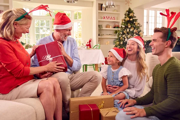 多代家庭在家中庆祝圣诞头戴圣诞帽 头戴安特卫斯开幕礼物 — 图库照片