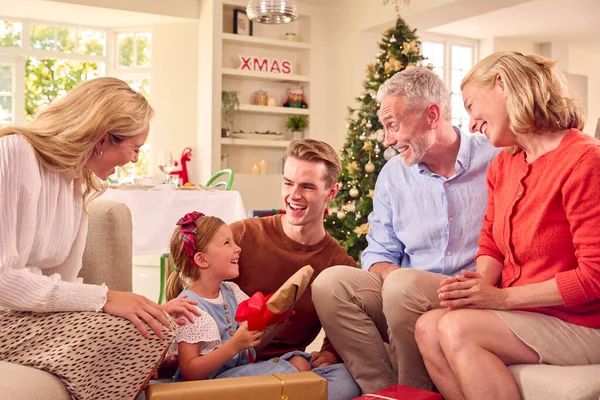 自宅でクリスマスを祝う多世代の家族が一緒にプレゼントを開く — ストック写真