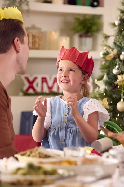 爸爸和女儿在家里庆祝家庭圣诞 在吃饭前都要头戴纸帽 — 图库照片