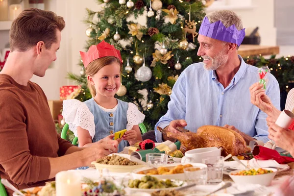 Multigenerační Rodina Slaví Vánoce Doma Otevření Crackers Před Jídlem Spolu — Stock fotografie