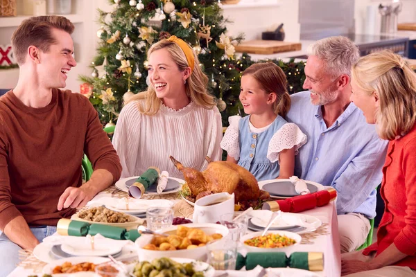 Familia Multigeneracional Celebrando Navidad Casa Comiendo Juntos Alrededor Mesa — Foto de Stock