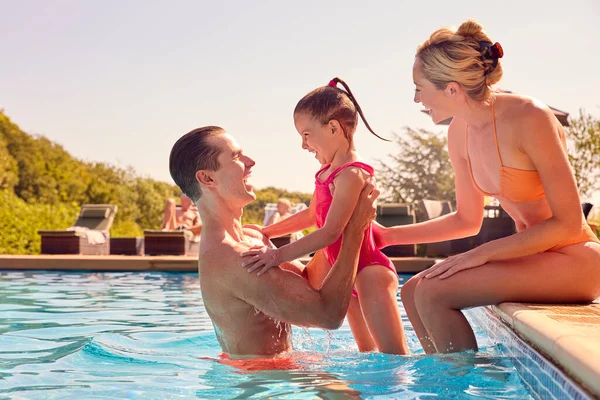 水泳プールで遊ぶ夏休みの笑顔の家族 — ストック写真