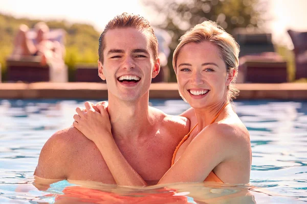 水泳プールでリラックスした夏休みのカップルの笑顔の肖像 — ストック写真