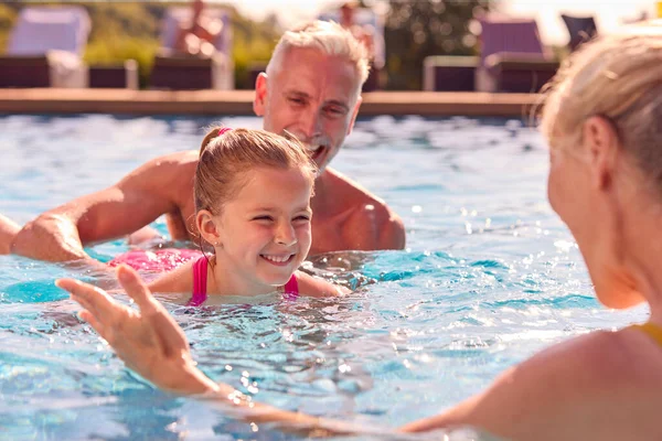 祖父母は孫にプールで家族の夏休みに泳ぐことを教えています — ストック写真