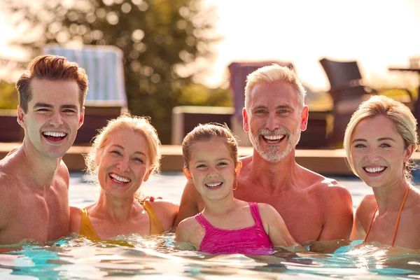 スイミングプールでの夏休みのリラックスした笑顔の多世代家族の肖像 — ストック写真