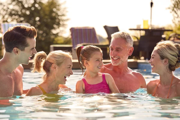 在游泳池的暑假放松中微笑的多代家庭 — 图库照片