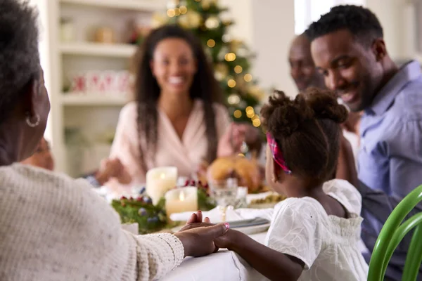 一緒に食事をする前に祈る家庭でクリスマスを祝う多世代の家族 — ストック写真