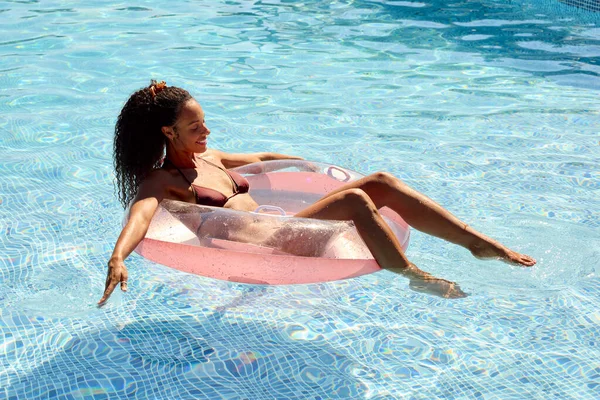 女子在夏日假期在游泳池里浮游 — 图库照片