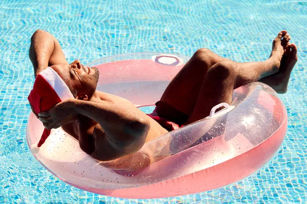 Man Christmas Holiday Floating Inflatable Swimming Pool Wearing Santa Hat — Stock Photo, Image