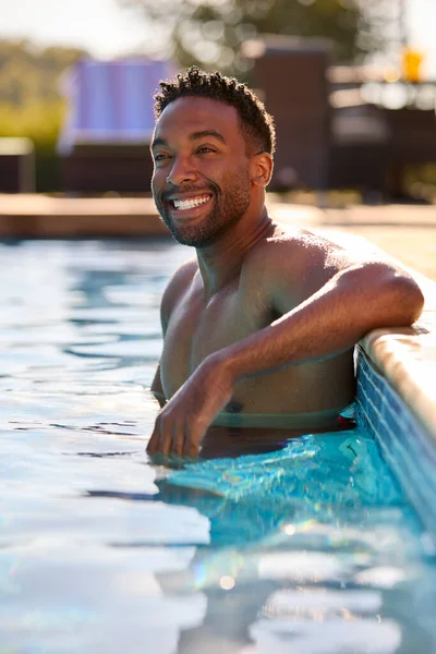 水泳プールでリラックスした夏休みの笑顔の男の肖像 — ストック写真