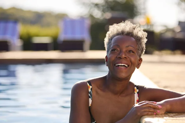 水泳プールで夏休みのリラックスした笑顔のシニア女性の肖像 — ストック写真