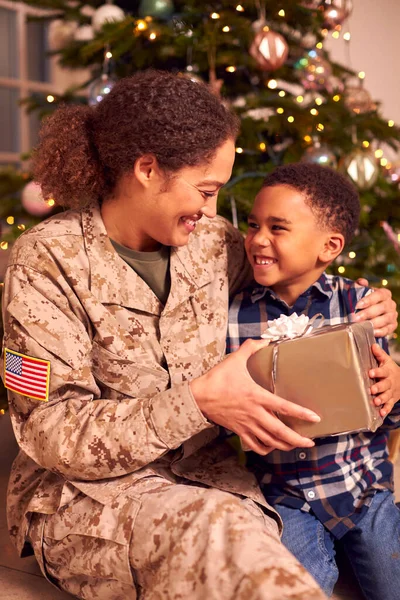 制服を着たアメリカ人女性兵士クリスマスのために家を出る息子プレゼント — ストック写真