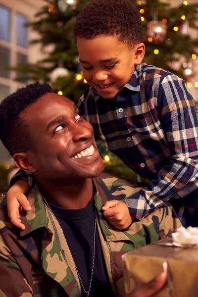身穿制服的美国士兵在圣诞节假期回家送儿子礼物 — 图库照片