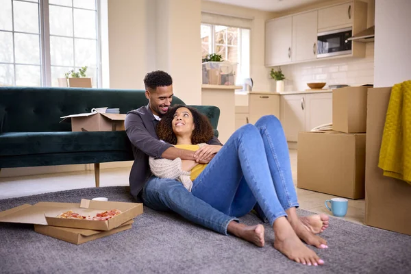 興奮したカップルが新しい家に移動床に座って祝うテイクアウトピザを食べる — ストック写真