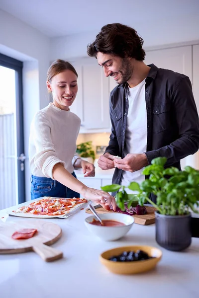家庭厨房里的情侣一起做自制比萨 — 图库照片