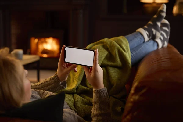 自宅でソファの上に寝そべっている女 コスプレ火災ストリーミングオンブランク画面携帯電話 — ストック写真