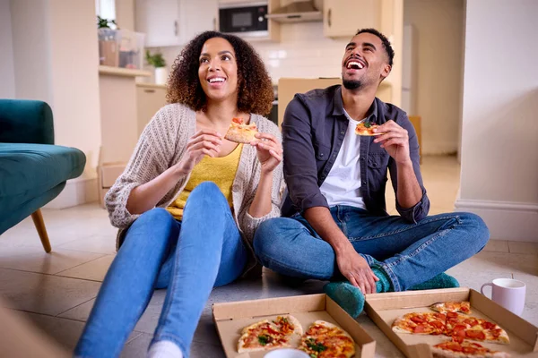 Izgatott Pár Költözik Otthonba Ülés Ünneplése Padlón Ülve Takeaway Pizza — Stock Fotó