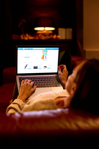 网上购物时 妇女坐在客厅里的后视镜 — 图库照片