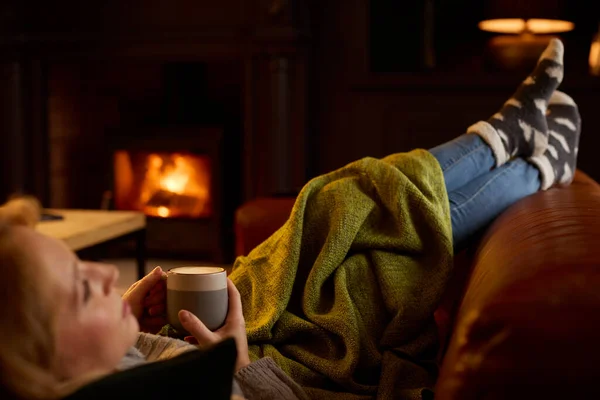 Vrouw Thuis Lounge Liggend Bank Met Gezellig Vuur Met Warm — Stockfoto