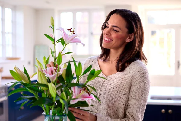 Evde Gülümseyen Kadın Cam Vazoda Çiçek Buketi Düzenliyor — Stok fotoğraf