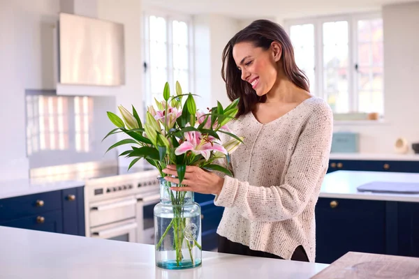 Evde Gülümseyen Kadın Cam Vazoda Çiçek Buketi Düzenliyor — Stok fotoğraf