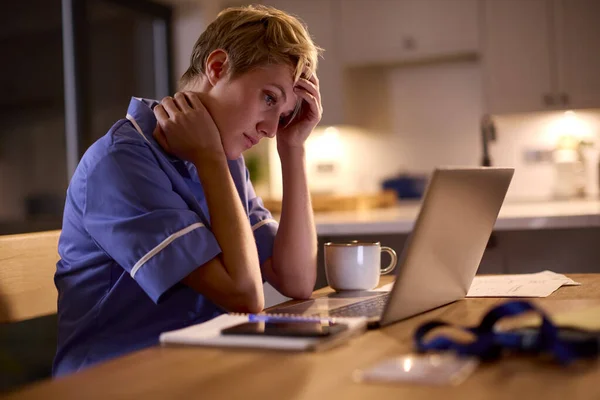 Втомлена Жінка Носить Медичні Скраби Працюють Або Навчаються Ноутбуці Вдома — стокове фото