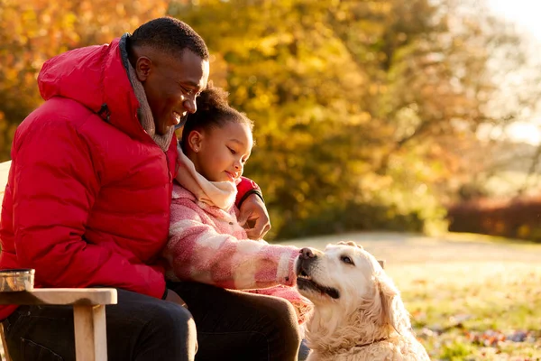 秋の田舎の散歩でペット犬とベンチに座っている父と娘と家族のショット — ストック写真