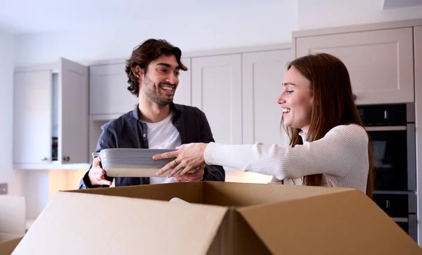 Casal Jovem Movendo Para Nova Casa Desempacotando Caixas Cozinha Juntos — Fotografia de Stock