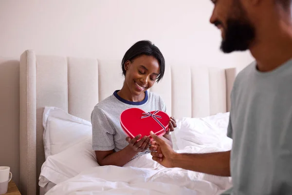 爱男人的女人在卧室里用浪漫的巧克力盒给女人惊喜 — 图库照片