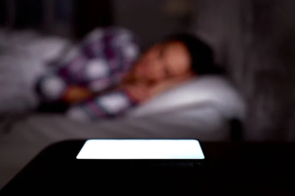 Evde Yatağında Cep Telefonuyla Uyuyan Bir Kadın Komodinin Üzerinde Işıldıyor — Stok fotoğraf