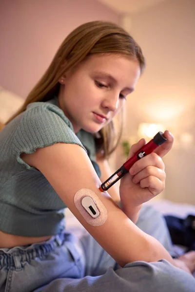 年轻的糖尿病女孩坐在床上在家用试剂盒测量和检查胰岛素水平 — 图库照片
