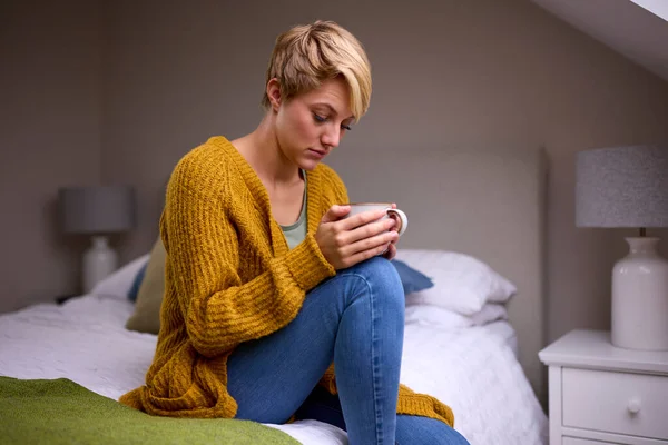 Evde Yatağında Sıcak Içecekle Oturan Mutsuz Genç Kadın — Stok fotoğraf