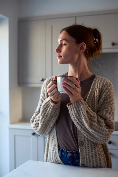 Young Woman Relaxing Home Kitchen Holding Hot Drink Eyes Closed — Stock Photo, Image